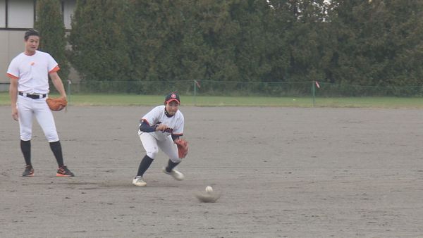 守備練習をする女子野球選手と高岸